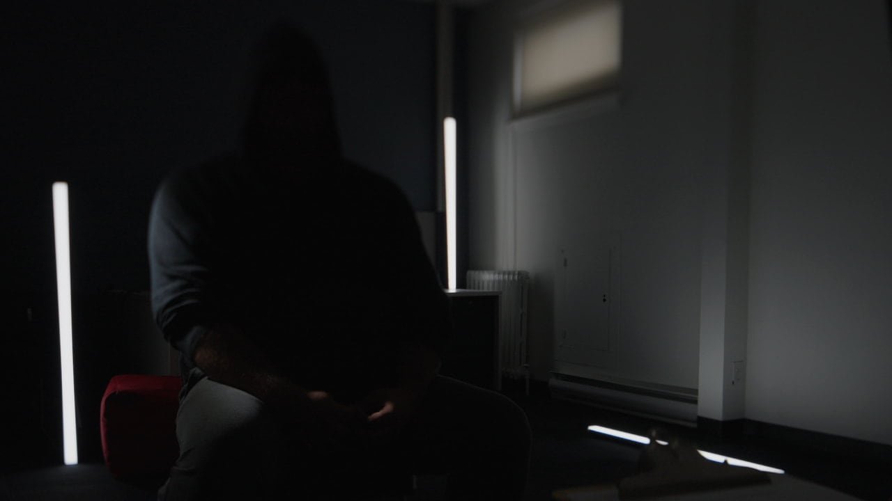 default-412 An unidentified man sits in a dark room.